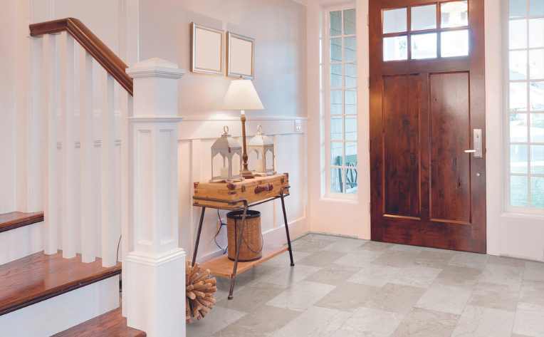 natural stone look luxury vinyl tile in modern entryway with wood accents